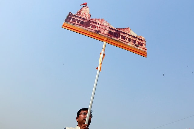 A supporter of the Vishva Hindu Parishad (VHP), a Hindu nationalist organisation,  carries a cutout of a proposed Ram temple that Hindu groups want to build at a disputed religious site in Ayodhya, during "Dharma Sabha" or a religious congregation organise