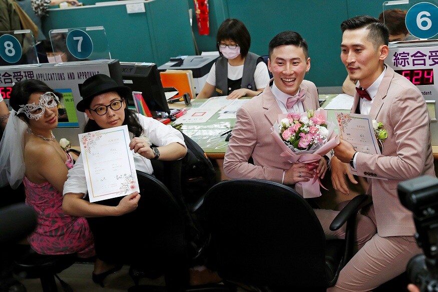 Couples Li Ying-Chien and Cynical Chick, and Marc Yuan and Shane Lin, pose for photographs after registering for same-sex marriage at the Household Registration Office in Shinyi District in Taipei