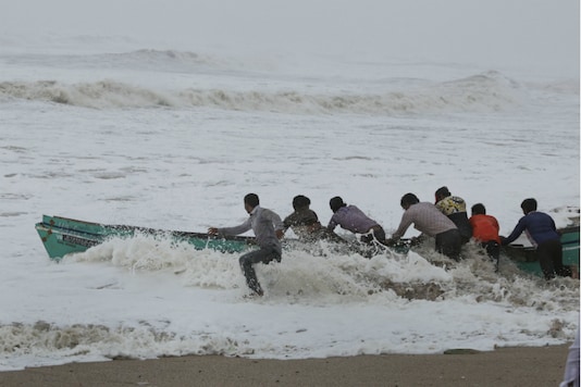 File photo of fishermen moving their boat from the rough sea waters to a safer place off the Veraval coast in Gujarat on Thursday. File photo of fishermen moving their boat from the rough sea waters to a safer place off the Veraval coast in Gujarat on Thursday.