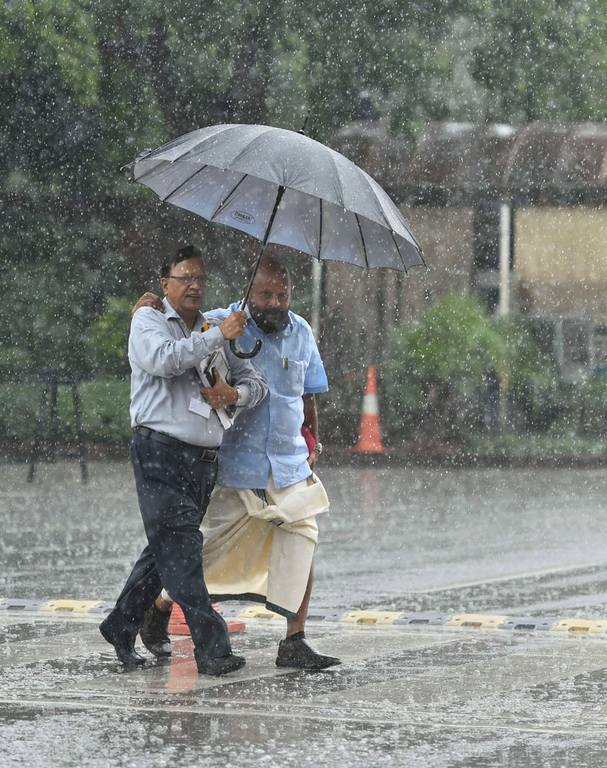 People cross a road during Monsoon rain, in New Delhi. (Image: PTI)
