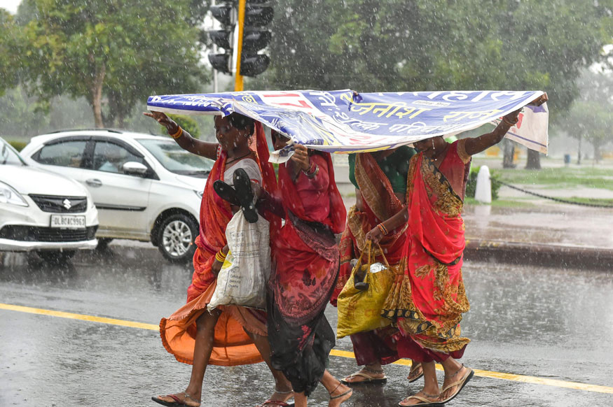 People cross a road during Monsoon rain, in New Delhi. (Image: PTI)