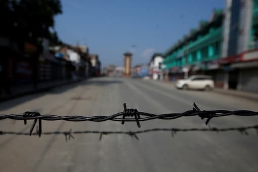 Barbed wire is seen laid on a deserted road during restrictions in Srinagar. (Image: Reuters)