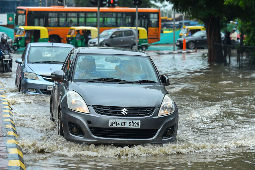 Vehicles wade through a waterlogged road during a shower, in New Delhi. (Image: PTI)