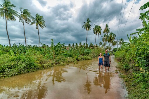 People wade through a flooded area following incessant rainfall in Hampi. (Image: PTI) People wade through a flooded area following incessant rainfall in Hampi. (Image: PTI)
