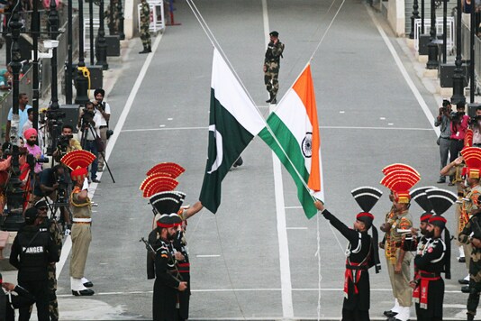 Pakistani Rangers (wearing black uniforms) and Indian Border Security Force (BSF) officers lower their national flags at the Pakistan-India joint check-post at Wagah border, on August 14, 2019. (REUTERS/Mohsin Raza)
