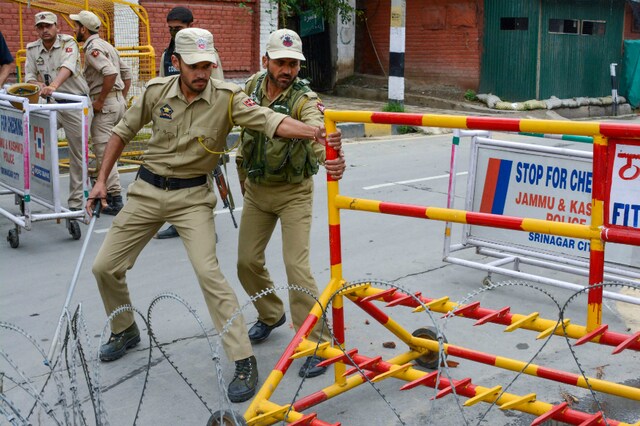 File photo of police personnel blocking the road near the residences of former chief ministers Omar Abdullah and Mehbooba Mufti, in Srinagar. (PTI Photo)