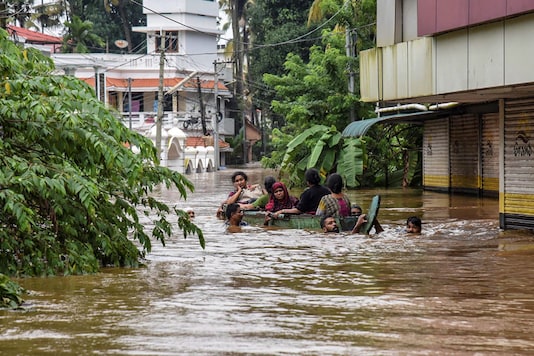File photo of people wading in neck-deep waters during the Kerala floods in 2018. File photo of people wading in neck-deep waters during the Kerala floods in 2018.