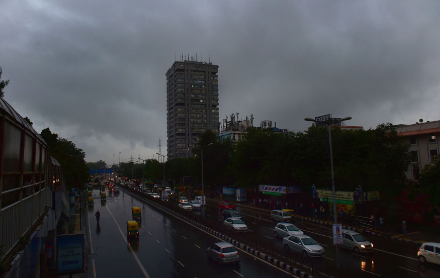Vehicles move with their headlights on as visibility gets poor before rains, near ITO in New Delhi. (Image: PTI)