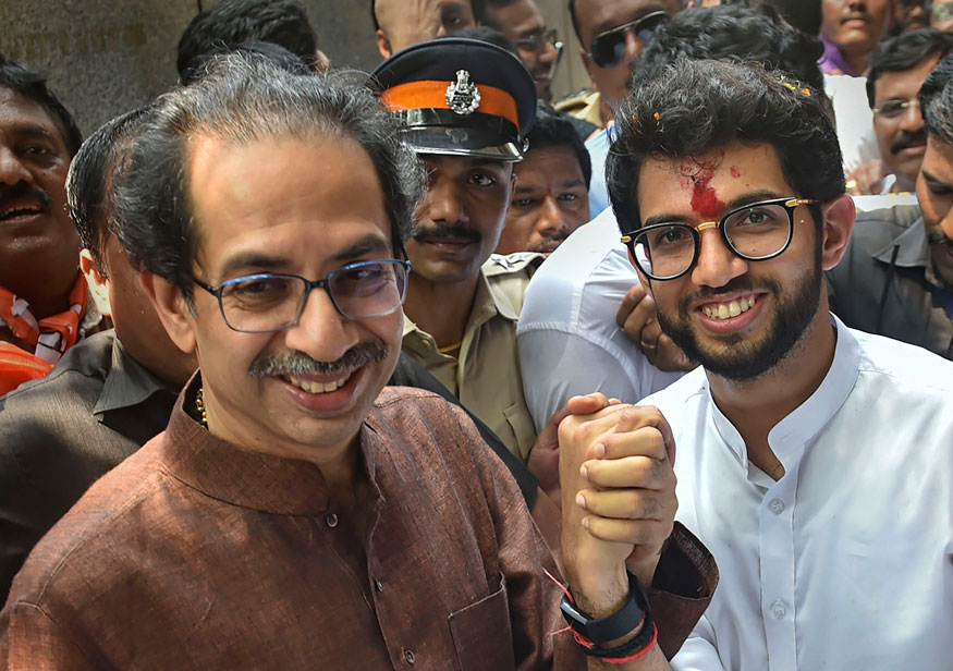 Shiv Sena President Uddhav Thackeray holds the hand of his son and Yuva Sena President Aditya Thackeray, after the former filed his nominations papers from Worli seat for upcoming Maharashtra Assembly elections, in Mumbai. (Image: PTI)