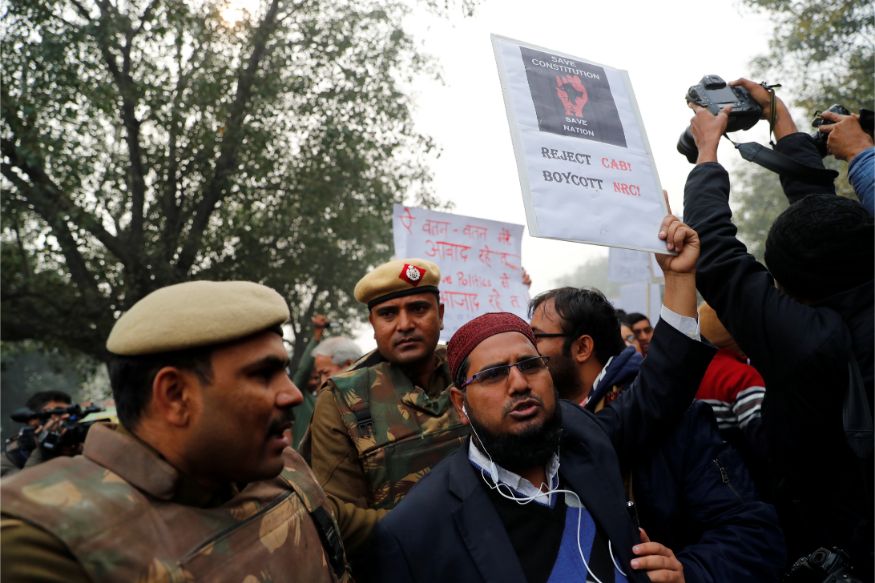 A demonstrator holds up a placard during a protest against a new citizenship law, in Delhi. (Image: Reuters)