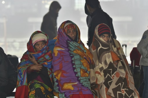  Passengers wrapped in blankets wait for their trains at a platform at the New Delhi railway station, during a cold and foggy morning in New Delhi, Monday, Dec 30,2019. A thick blanket of fog engulfed the national capital on Monday morning affecting train and flight operations as visibility dropped drastically, with some observatories recording it at zero metres.