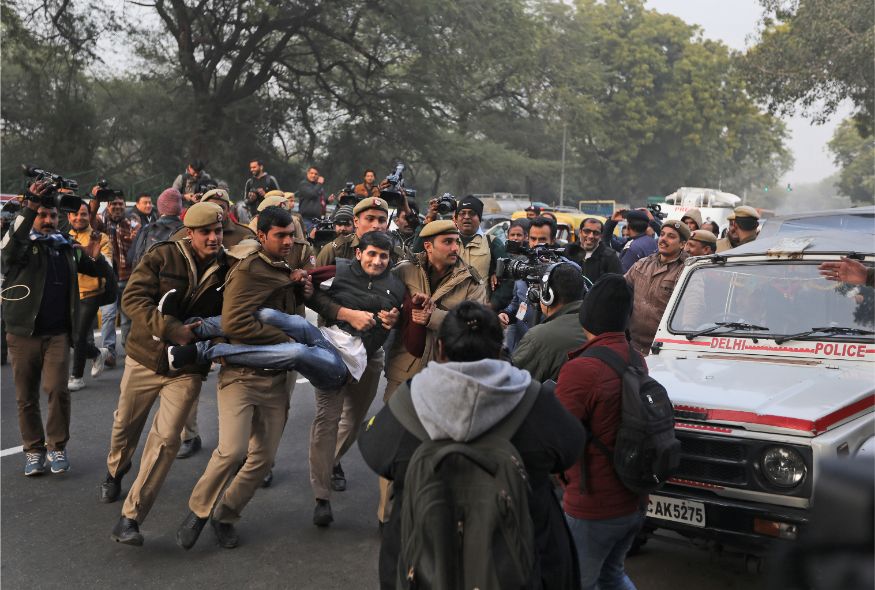 A protesting student is detained by a policemen outside Uttar Pradesh Bhawan during a protest against a new citizenship law and violence by police in the state, in New Delhi. (Image: AP)