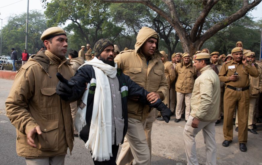A policeman detains a protester outside Uttar Pradesh Bhawan as he participates in a protest against violence by police that have arisen during demonstrations against the new citizenship law in the state, in New Delhi. (Image: AP)