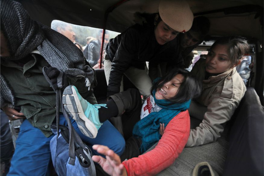 Policewomen detain a student protesting outside Uttar Pradesh Bhawan against a new citizenship law and violence by police in the state, in New Delhi. (Image: AP)