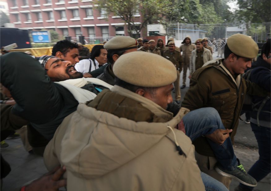 Policemen detain a student outside Uttar Pradesh Bhawan during a protest against a new citizenship law and violence by police in the state, in New Delhi. (Image: AP)