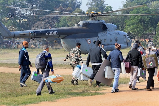 Polling personnel carry their equipment as Jharkhand Armed Police (JAP) jawans keep vigil at a helipad during Jharkhand assembly election in Hazaribagh. (PTI File) Polling personnel carry their equipment as Jharkhand Armed Police (JAP) jawans keep vigil at a helipad during Jharkhand assembly election in Hazaribagh. (PTI File)
