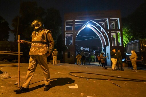 Policemen stand guard near Jamia Millia Islamia following the protests against Citizenship Amendment Act, in New Delhi, on Sunday. (PTI)