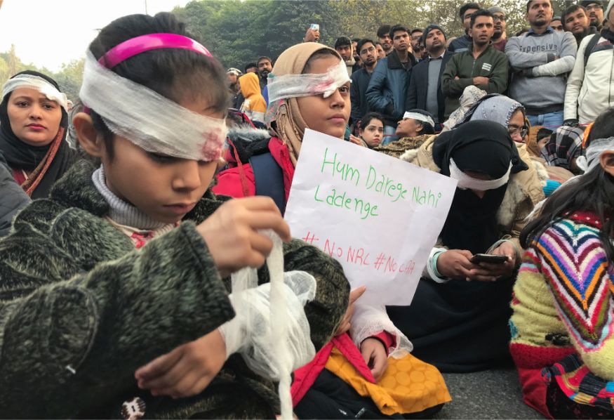 Protesters wearing symbolic bandages in solidarity with a student who lost his eye after being hit by a police baton during December 15 protests gather at Jamia University in New Delhi. (Image: AP)