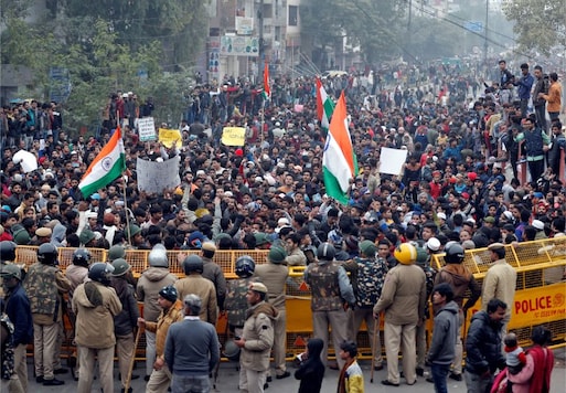 Demonstrators gather behind a police barricade during a protest against a new citizenship law and to show solidarity with the students of the Jamia Millia Islamia university after police entered the university campus on Sunday following a protest against the law, in Seelampur, Delhi. (Image: Reuters) Demonstrators gather behind a police barricade during a protest against a new citizenship law and to show solidarity with the students of the Jamia Millia Islamia university after police entered the university campus on Sunday following a protest against the law, in Seelampur, Delhi. (Image: Reuters)