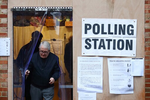 An elder leaves the garage of a residential house, converted to a poling station, to vote in the general election in South Croydon, in London. (Image : Reuters)
