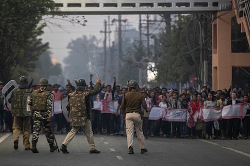 Police and paramilitary personnel stop protesters during a curfew in Gauhati, India, Thursday, Dec. 12 (AP)