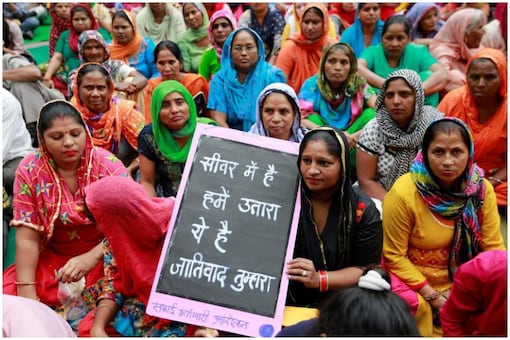 Women sanitation workers and families of male manual scavengers attend a protest against the rising deaths of people cleaning sewers, in New Delhi, India, September 25, 2018 | Image credit: Reuters/Adnan Abidi
