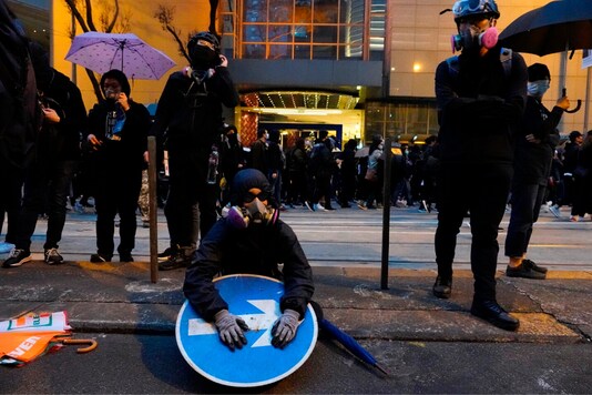 A group of protestors take rest as others march behind in the New Year's day rally in Hong Kong . (Image : AP)