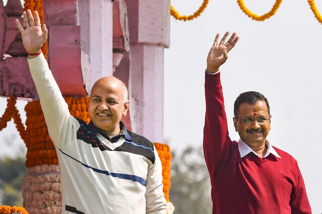 Chief Minister Arvind Kejriwal and newly sworn-in minister Manish Sisodia wave at crowd after their oath ceremony at Ramlila Maidan in New Delhi (PTI)