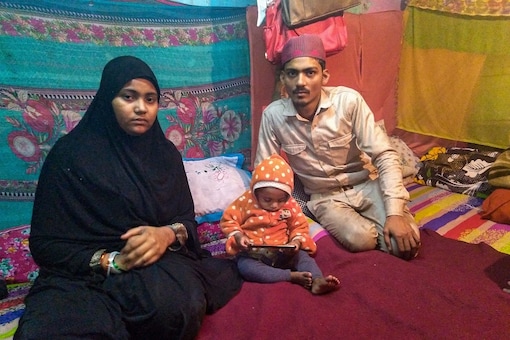 Mohammed Arif (R) and Nazia with one of their surviving children pose for photographs at their residence in Batla House, New Delhi, Monday, Feb. 3, 2020. Arif and Nazia's infant son, whom they used to take to the Shaheen Bagh protests, reportedly died due to cold. (Image: PTI)