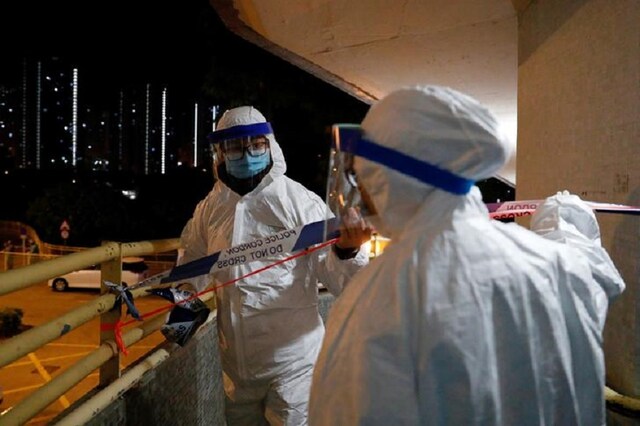 Personnel in protective gear prepare to evacuate residents from a public housing building following the outbreak of the novel coronavirus, in Hong Kong, China. (Reuters)