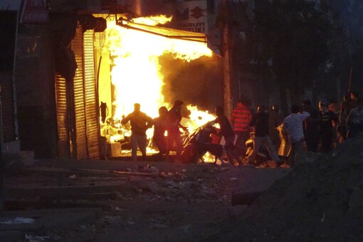 A mob sets a shop on fire in a riot-hit area of New Delhi on February 25, 2020. (AP)