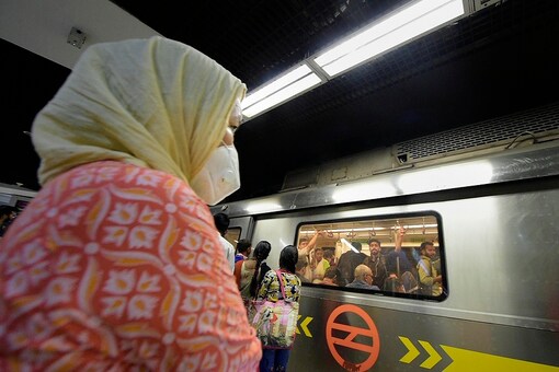 A commuter wearing a protective mask in wake of the deadly novel coronavirus, waits to board metro at a station, in New Delhi, Wednesday, March 4, 2020. (Image: PTI)