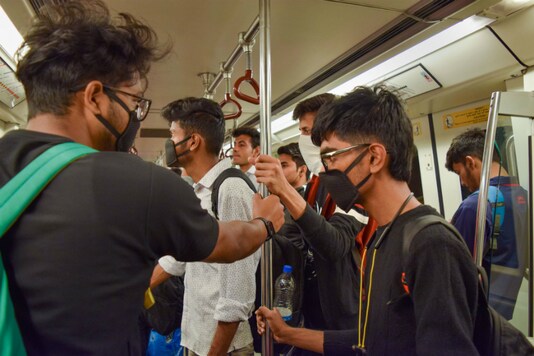 Passengers wear masks while travelling in a metro in New Delhi on Thursday. (PTI)