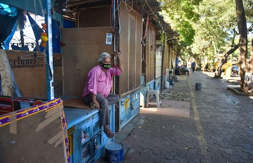Representative Image. A man wearing a protective mask in the wake of coronavirus pandemic, sits at one of the closed shops. (PTI Photo/Mitesh Bhuvad)
