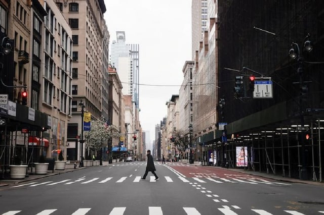 A man crosses a nearly empty 5th Avenue in midtown Manhattan during the outbreak of the coronavirus disease (COVID-19) in New York City, New York, US. (Reuters)