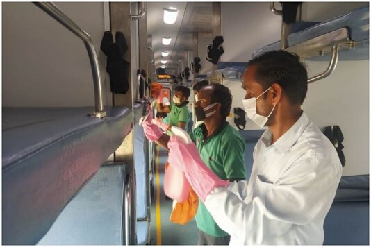 A worker is seen cleaning train to prevent the AC virus from spreading. (Image: News18/ Ajay Kumar)