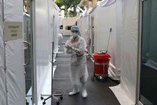 A health worker cleans her hands outside a makeshift tents place in the parking lot of Samitivej Hospital to check suspect patients of coronavirus disease (COVID-19) after the outbreak in Bangkok, Thailand March 22, 2020. REUTERS/Jorge Silva