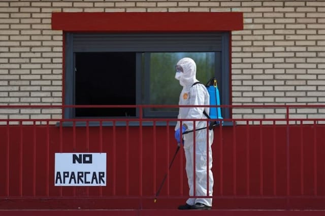 An emergency worker disinfects a corridor in Getafe, Spain. (Reuters)