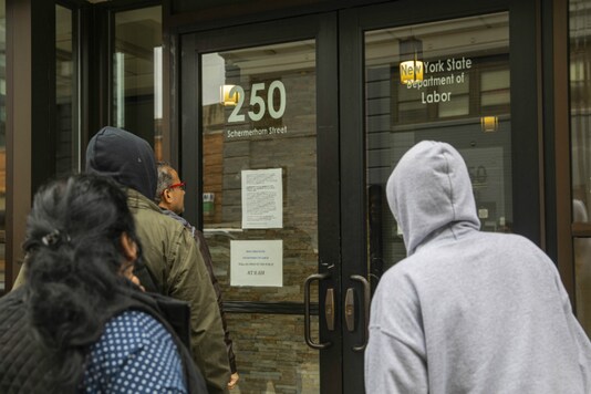 People wait outside the New York State Department of Labor office in New York, on March 19, 2020. (Hiroko Masuike/The New York Times) People wait outside the New York State Department of Labor office in New York, on March 19, 2020. (Hiroko Masuike/The New York Times)