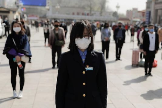People wearing face masks stand to pay tribute as China holds national mourning for those who died of the coronavirus disease (COVID-19), on the Qingming tomb-sweeping festival, in Beijing. (Reuters)