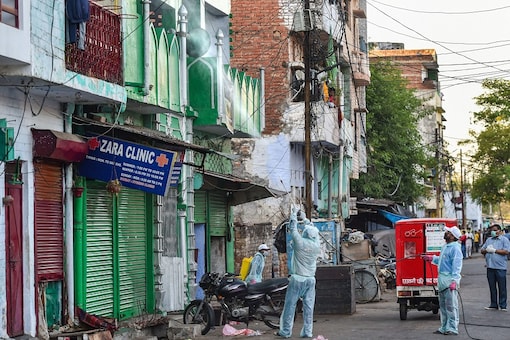 Volunteers spray disinfectants on the building of Ali Jan mosque, after some people staying there were tested positive of coronavirus, at Sadar Bazar area of Lucknow, Uttar Pradesh. (PTI Photo)