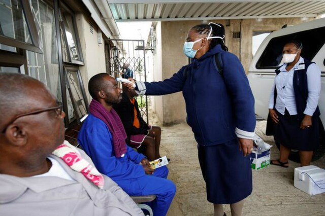 A health worker checks a man's temperature in Durban, South Africa. (Reuters)
