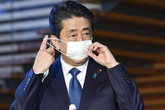 Japanese Prime Minister Shinzo Abe takes off mask as he speaks to reporters at the prime minister's official residence in Tokyo. (Image: AP)