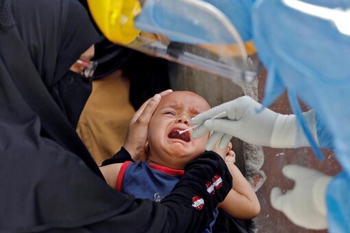 A child cries as a doctor in protective gear takes a swab from him to test for coronavirus. (Reuters)