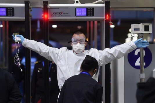 A man wearing protective gear gets through security check at Wuchang Railway Station before travel restrictions to leave Wuhan are lifted. (Reuters)