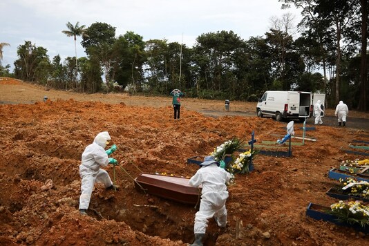Gravediggers wearing protective clothing prepare to bury coronavirus victim at the Parque Taruma cemetery in Manaus, Brazil. (REUTERS)