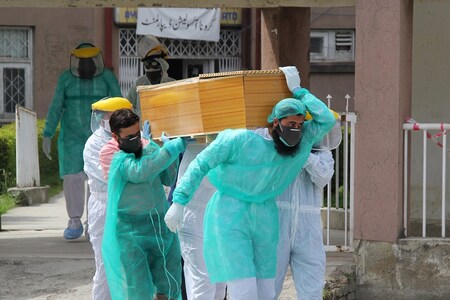 Health workers wearing protective gear move a body of a man who died from the coronavirus disease (COVID-19), outside an isolation ward at the Ayub Teaching Hospital in Abbottabad, Pakistan. (Reuters)
