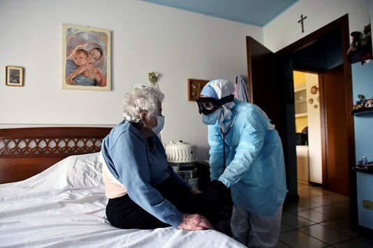A doctor in protective suit visits a person suffering from the coronavirus disease (COVID-19) at her home in Bergamo, the epicentre of Italy's outbreak. REUTERS/Flavio Lo Scalzo