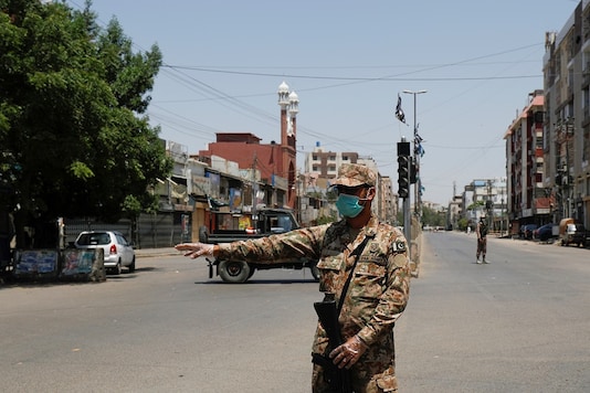 An army soldier gestures along a deserted road leading to a mosque during a lockdown after government limited congregational prayers and ordered to stay home, in efforts to stem the spread of the coronavirus disease (COVID-19), in Karachi, Pakistan. (Reuters)