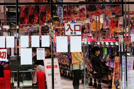 Visitors play pachinko, a Japanese form of legal gambling, at a pachinko parlour, after the government announced nationwide state of emergency following the coronavirus disease (COVID-19) outbreak, in Tokyo, Japan April 22, 2020. REUTERS/Kim Kyung-Hoon
